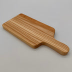 Wooden paddle cutting board on a light gray background