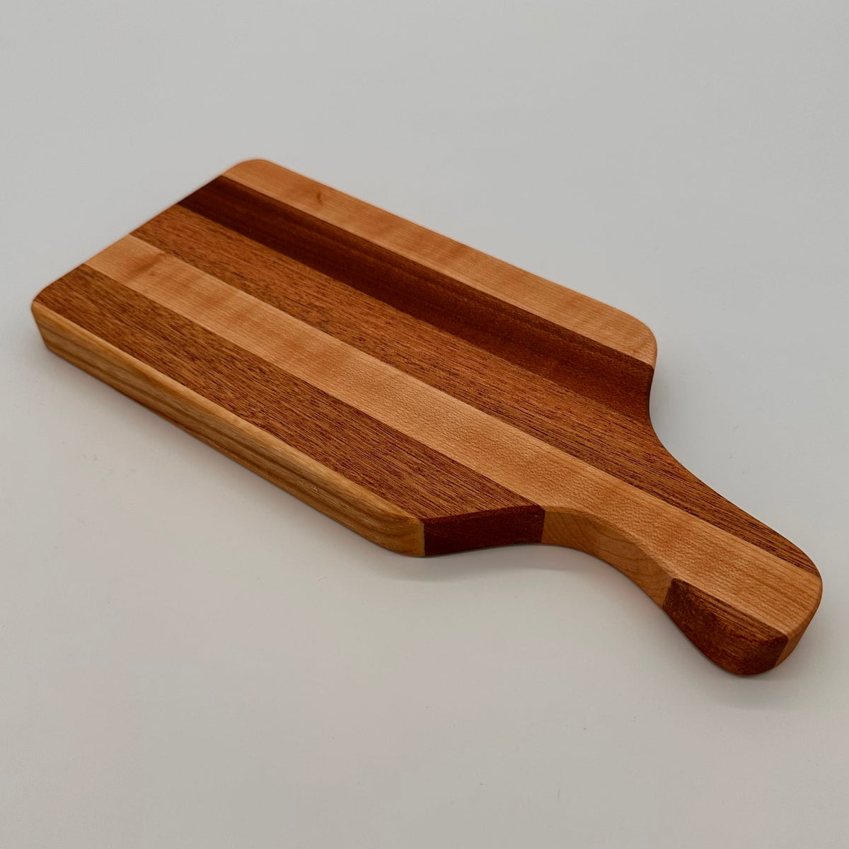 Wooden cutting board with a handle on a light gray background