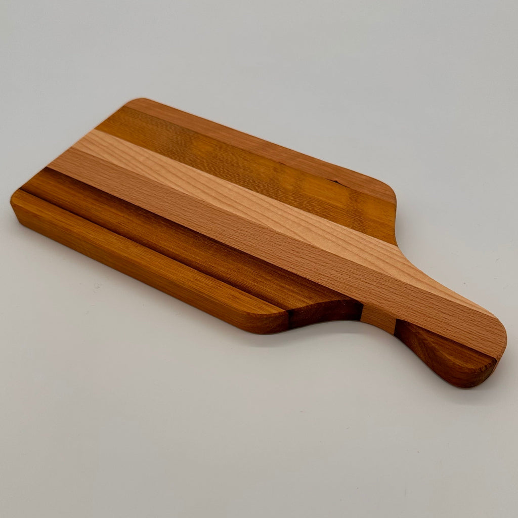 Wooden cutting board with a handle on a light gray background