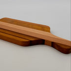 Wooden cutting board with handle on a light gray background