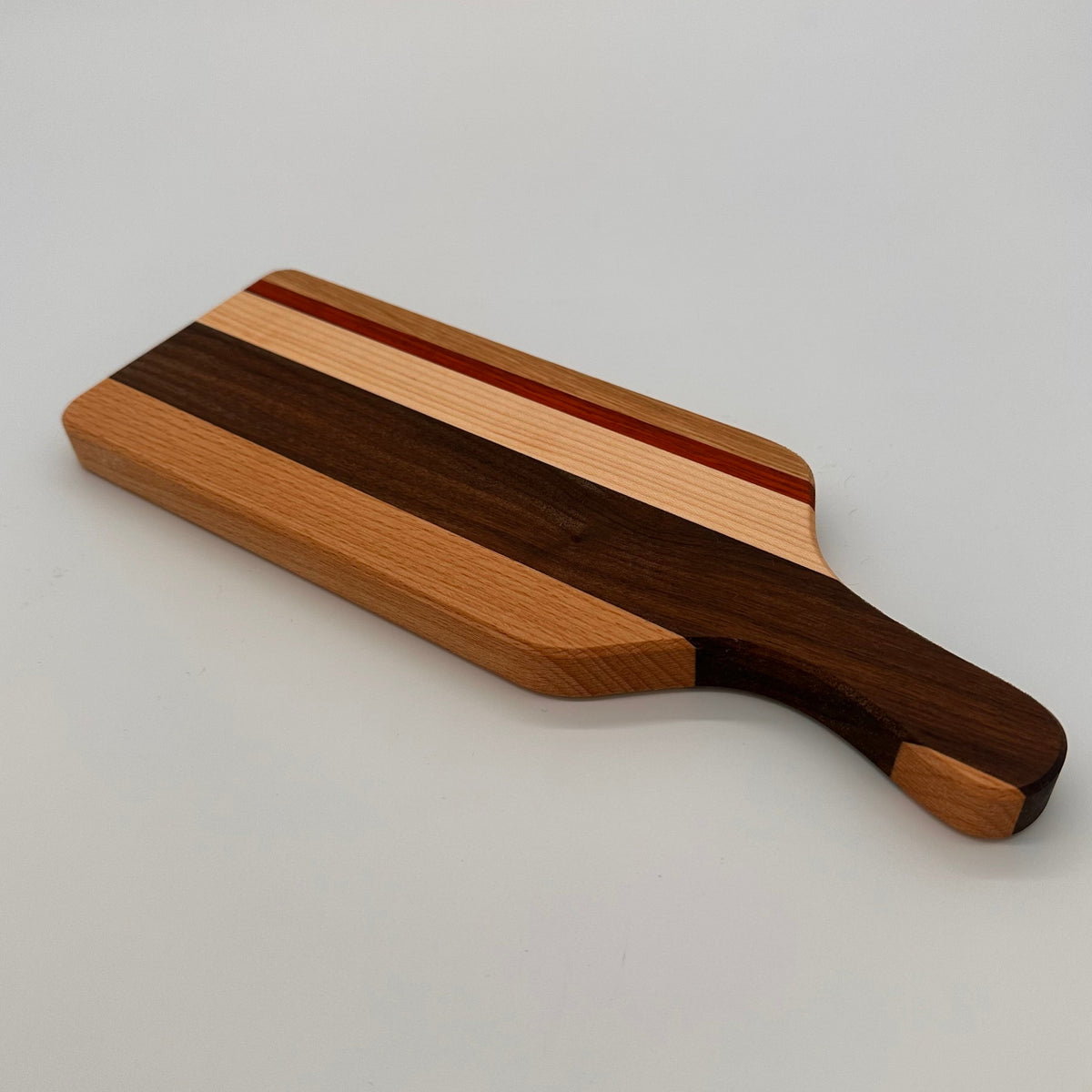 Wooden cutting board with a handle on a light gray background