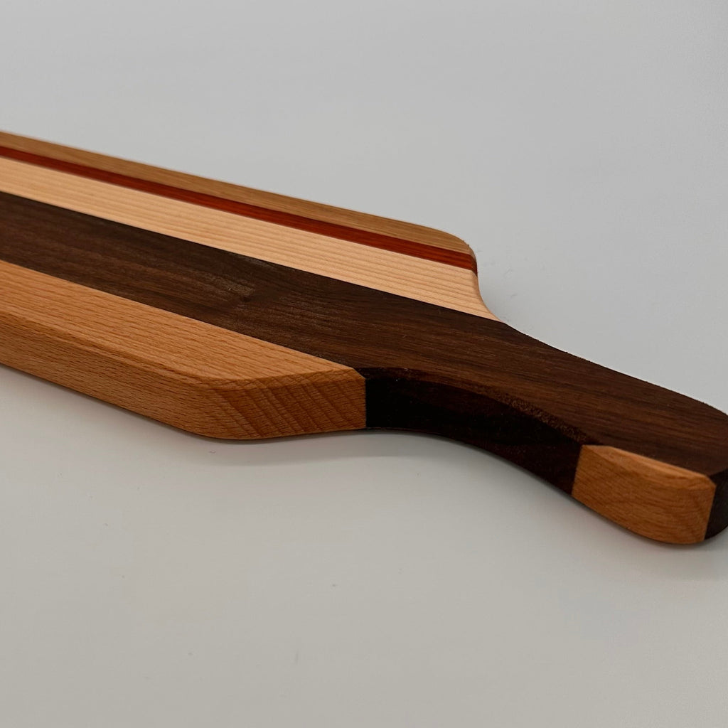 Wooden cutting board with a handle on a light gray background