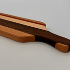 Wooden cutting board with a handle on a light gray background