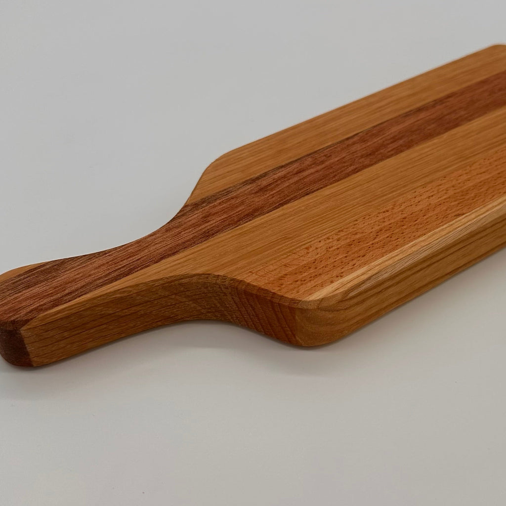Wooden cutting board with a handle on a light gray background