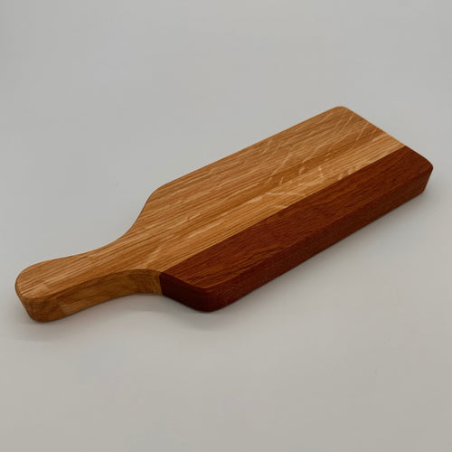 Wooden cutting board with a handle on a light gray background