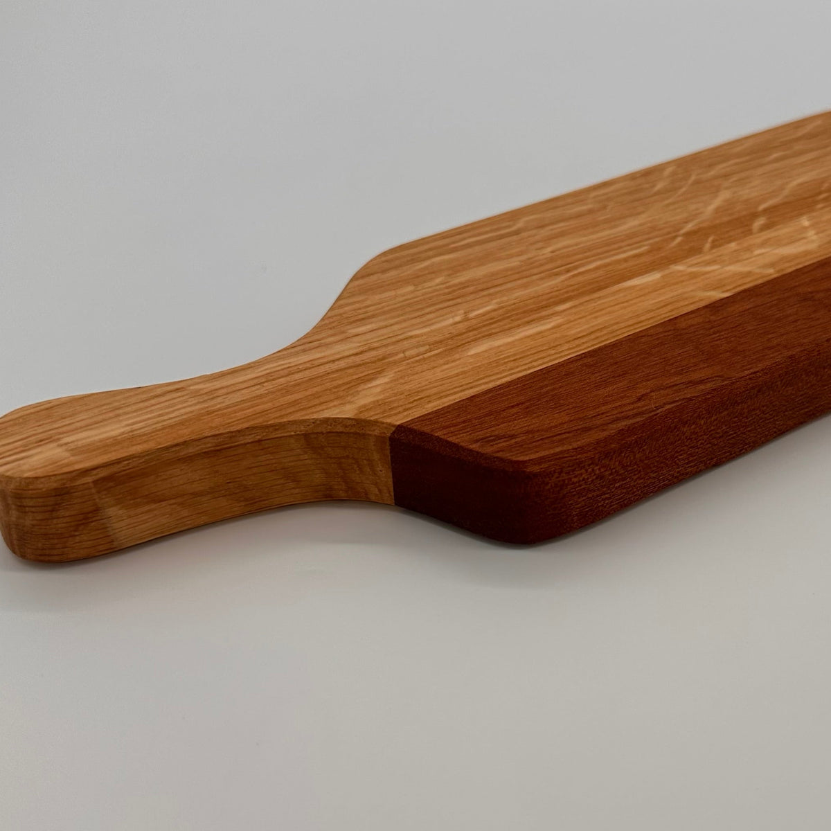 Wooden cutting board with a handle on a gray background