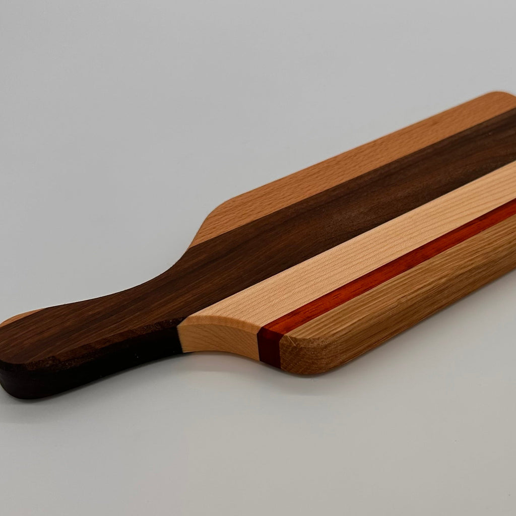 Wooden cutting board with a handle on a gray background