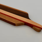 Wooden cutting board with a handle on a gray background