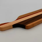 Wooden cutting board with a handle on a gray background