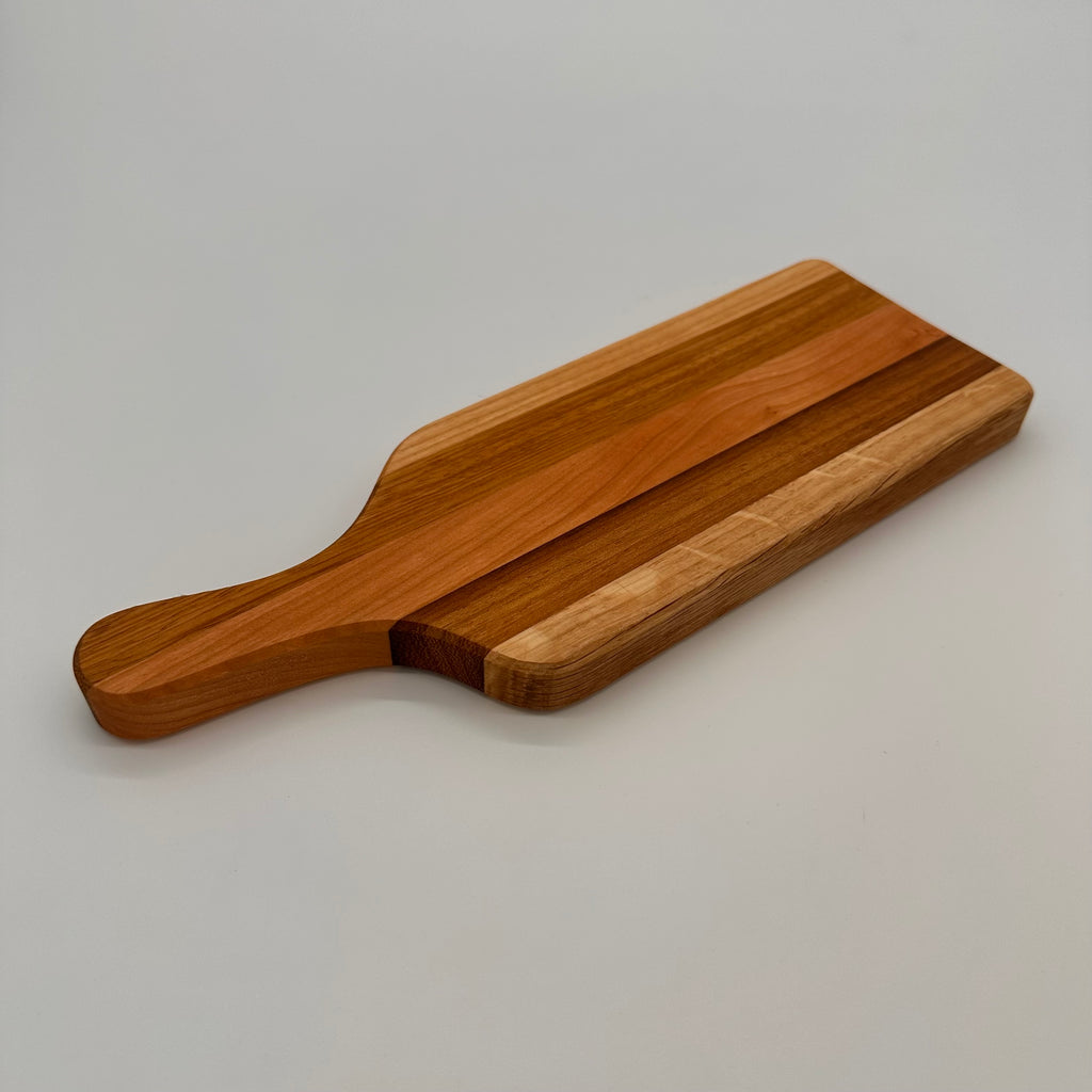 Wooden cutting board with a handle on a gray background