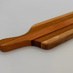 Wooden cutting board with a handle on a light gray background