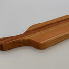 Wooden cutting board with a handle on a light gray background