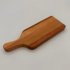 Wooden cutting board with handle on a light gray background