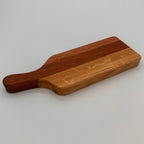 Wooden cutting board with a handle on a light gray background