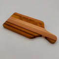 Wooden cutting board with a handle on a light gray background
