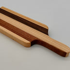 Wooden cutting board with a handle on a light gray background