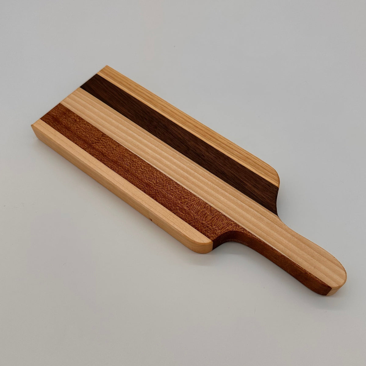 Wooden serving board with a handle on a light gray background