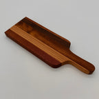 Wooden cutting board with a handle on a light gray background