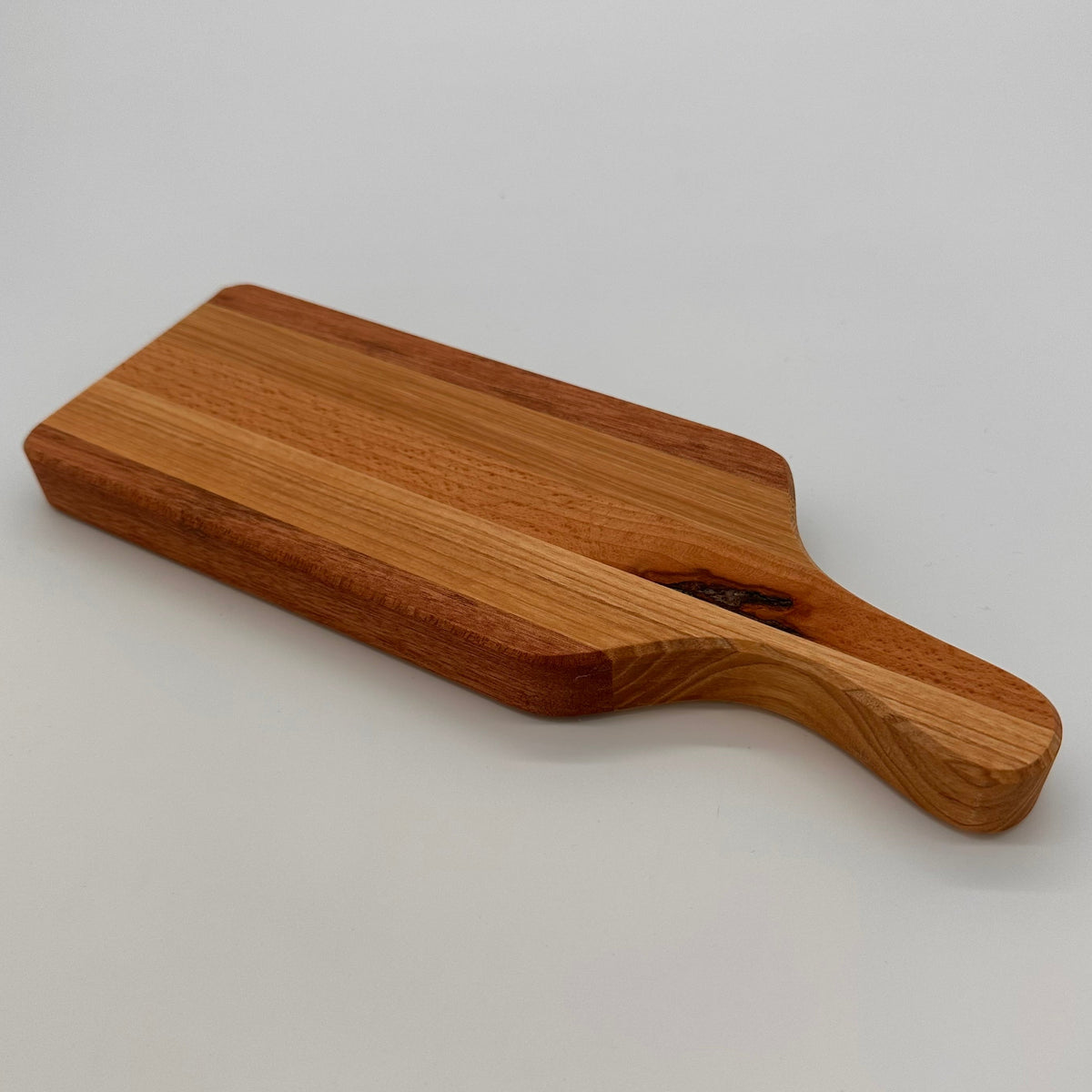 Wooden cutting board with handle on a light gray background