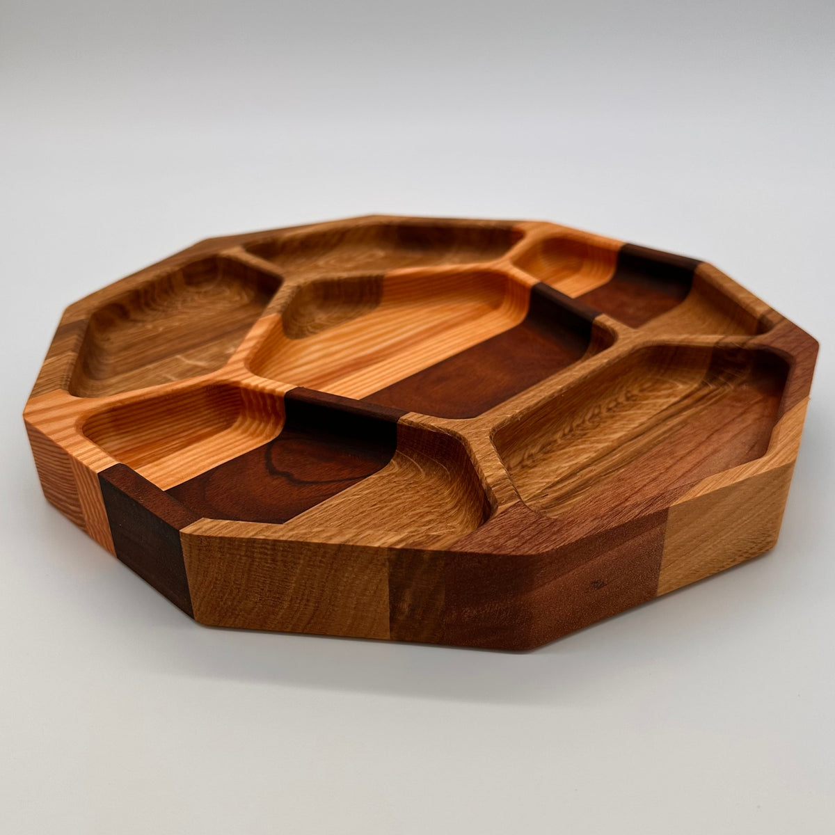 Wooden tray with geometric compartments on a white background