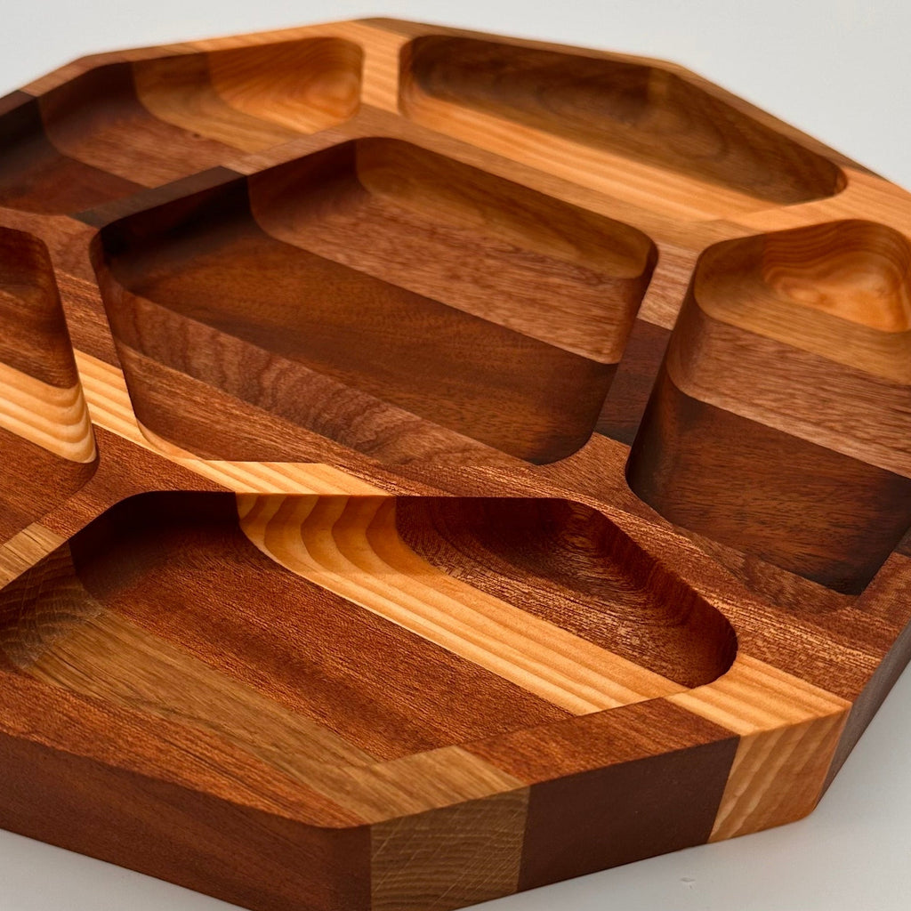 Wooden tray with multiple compartments on a light gray background