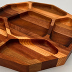 Wooden tray with multiple compartments on a light gray background