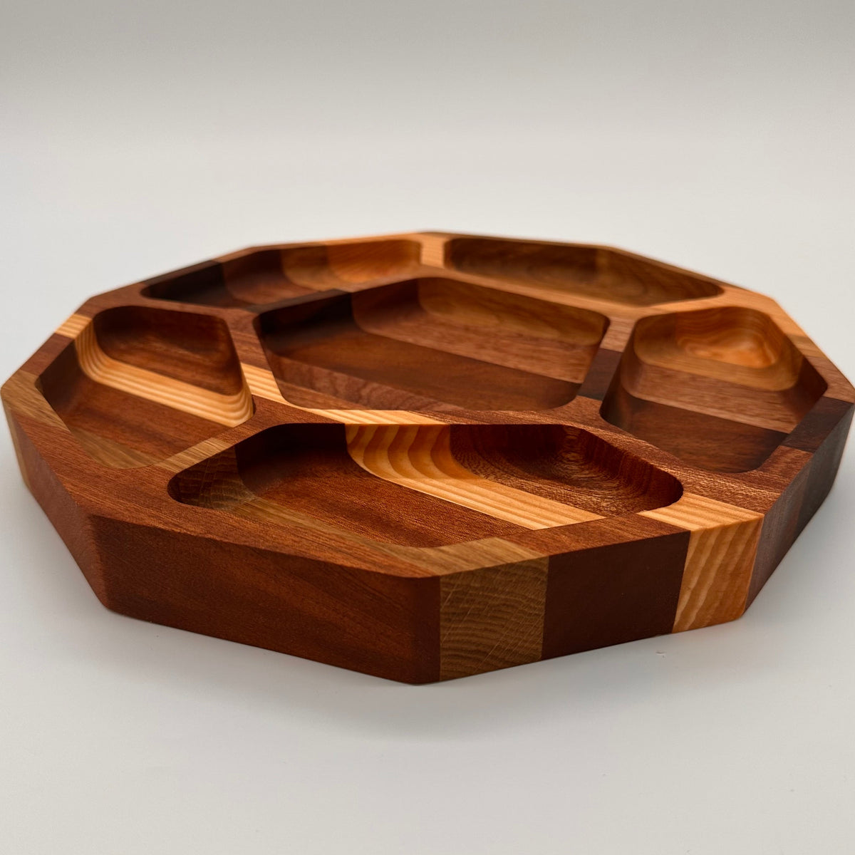 Wooden cutting board with segmented design on a light gray background