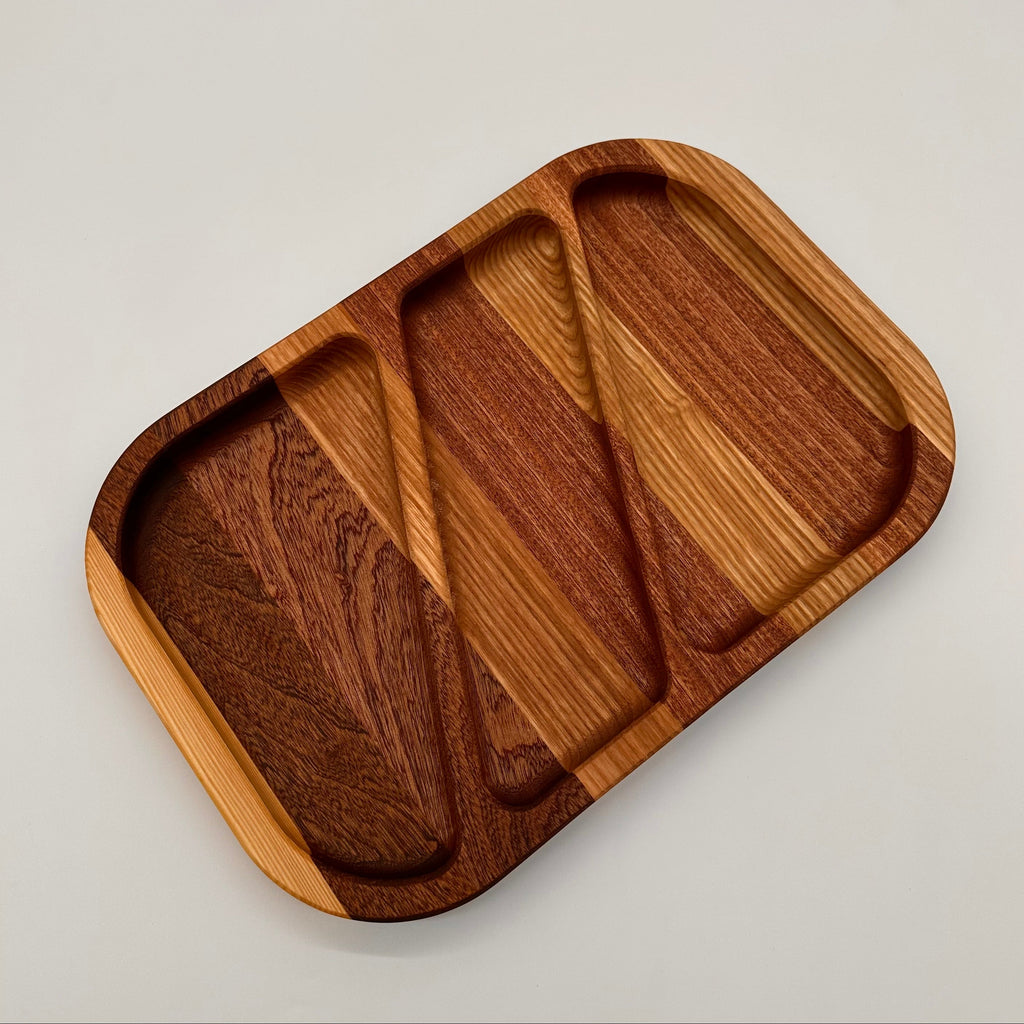 Wooden tray with three compartments on a light gray background