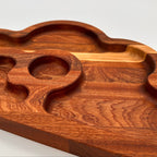 Wooden cutting board with wavy edge design on a white background