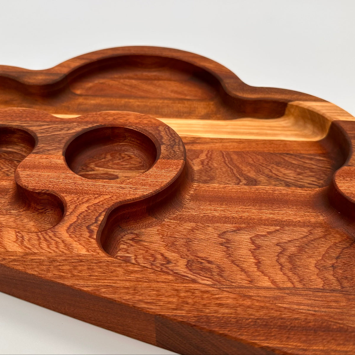 Wooden cutting board with wavy edge design on a white background