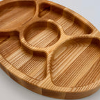 Wooden tray with divided sections on a light gray background