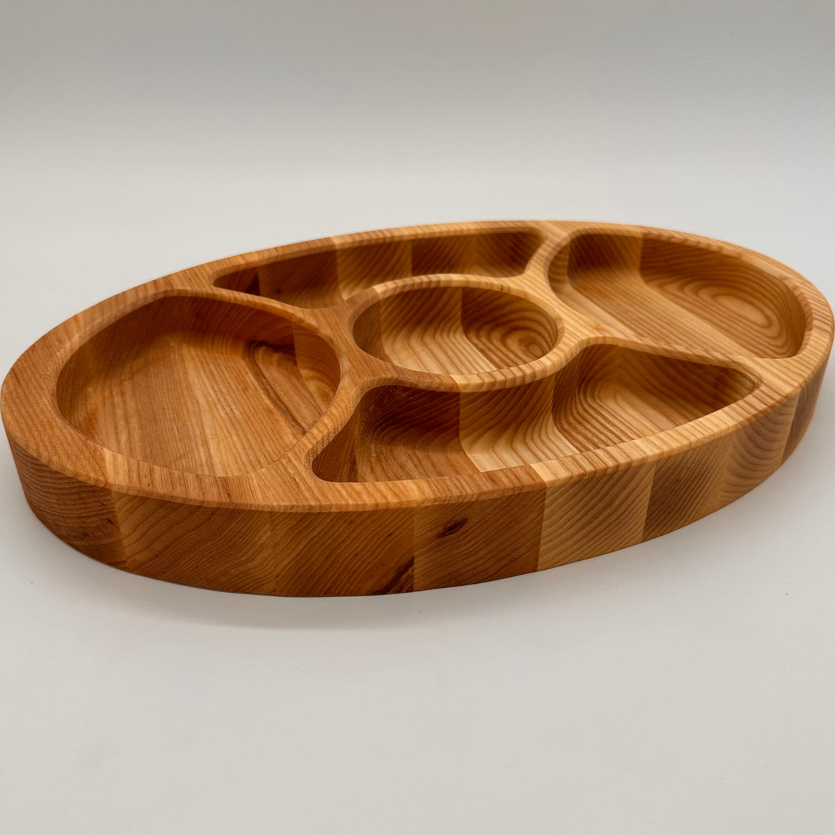 Wooden tray with divided sections on a light gray background