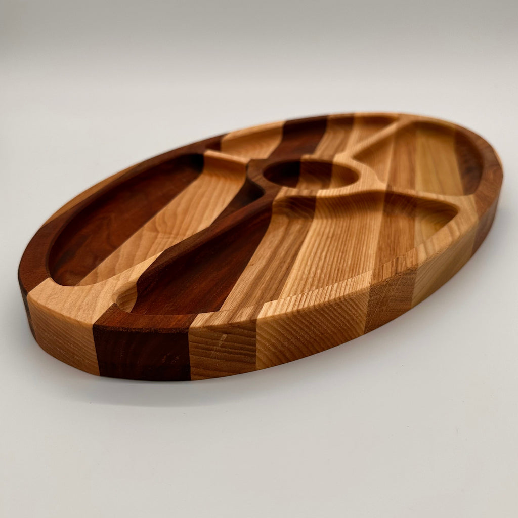 Wooden cutting board with divided sections on a light gray background