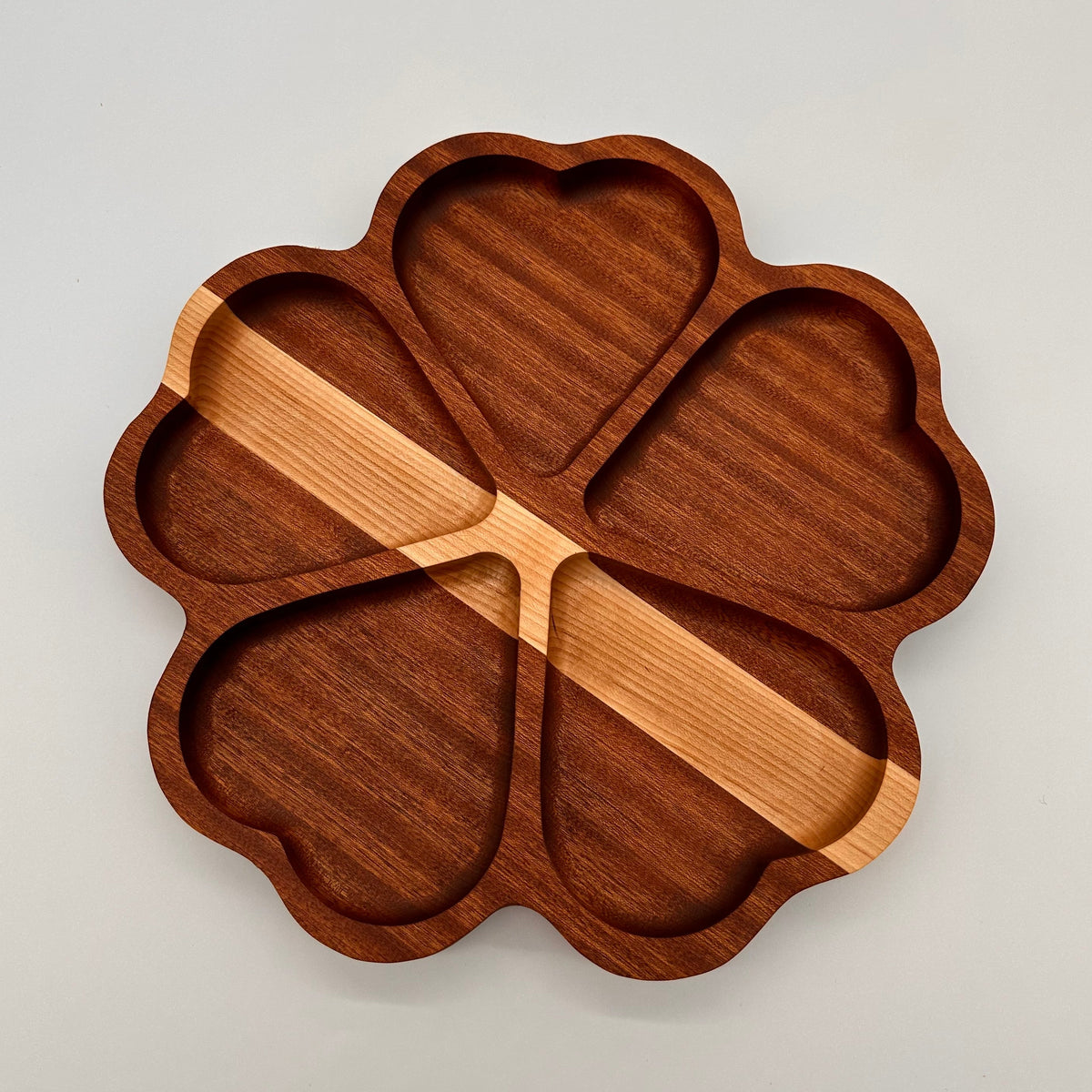 Wooden tray with a cloverleaf design on a light gray background