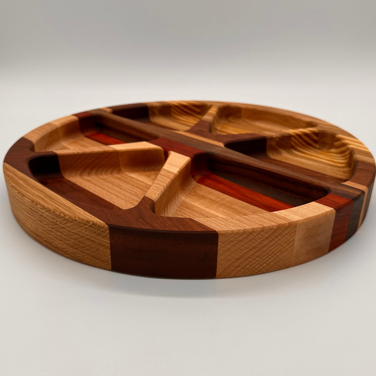 Wooden cutting board with segmented design on a white background