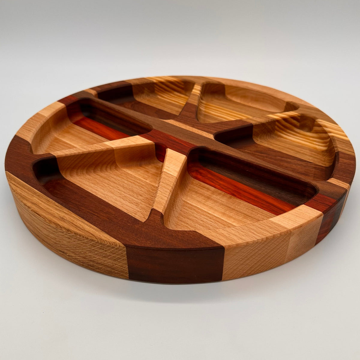 Wooden cutting board with segmented design on a white background
