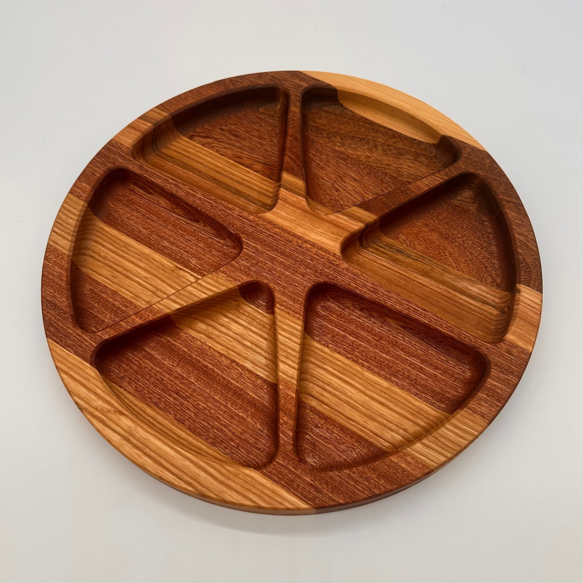 Wooden plate with divided sections on a light gray background