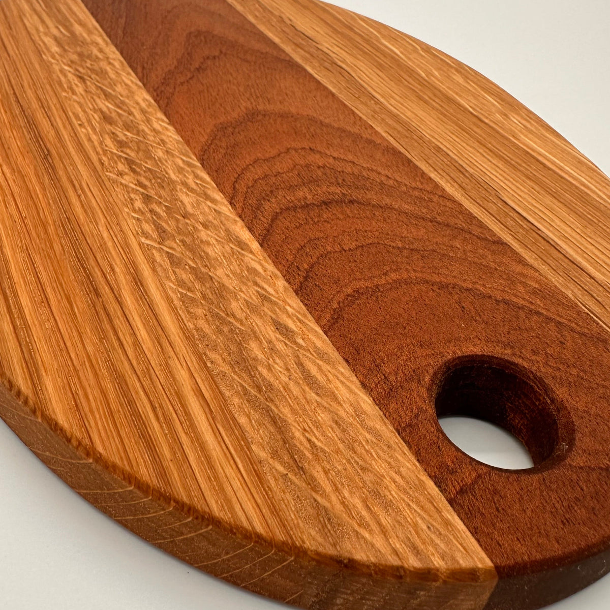 Wooden cutting board with a hole for hanging on a white background