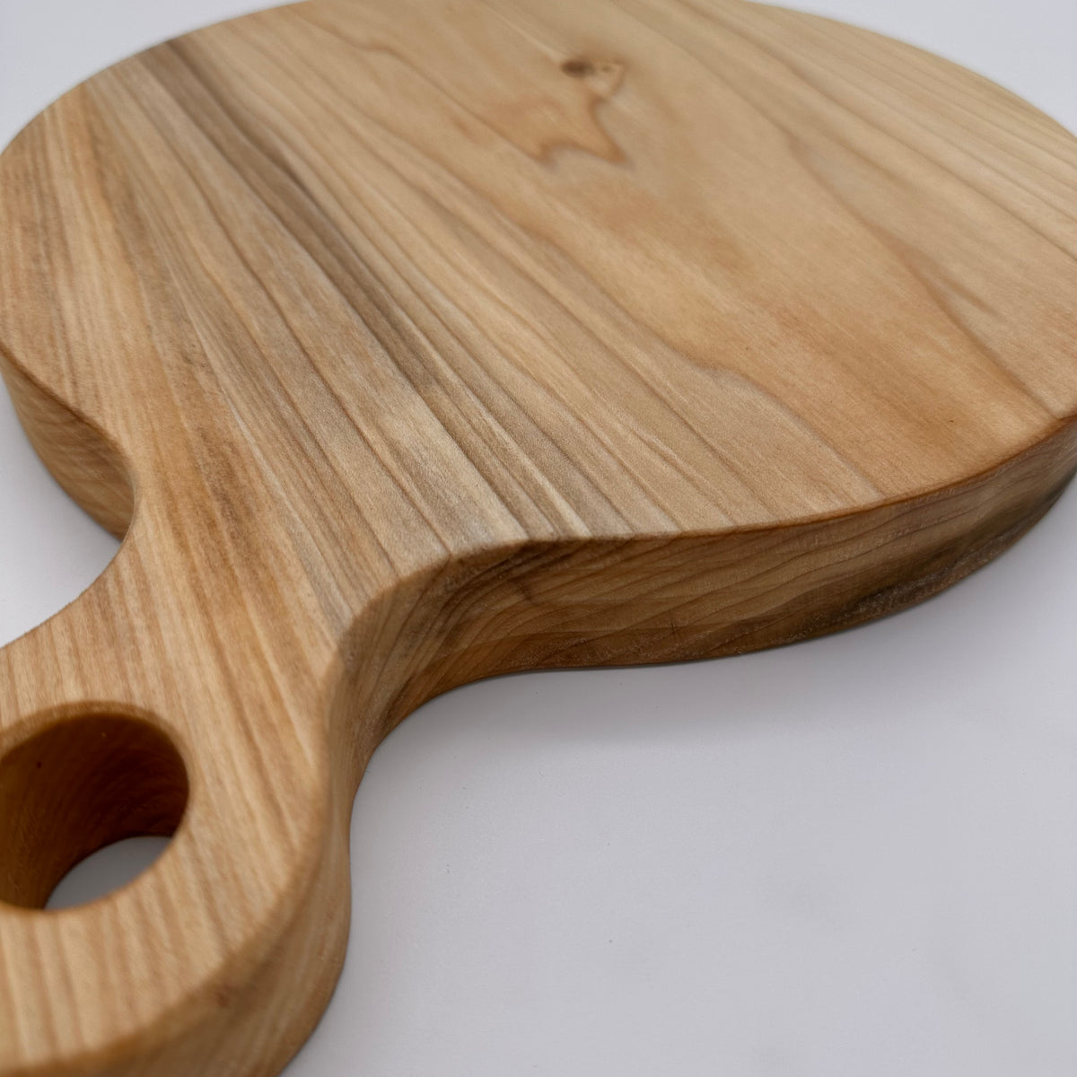 Wooden cutting board with handle on a white background
