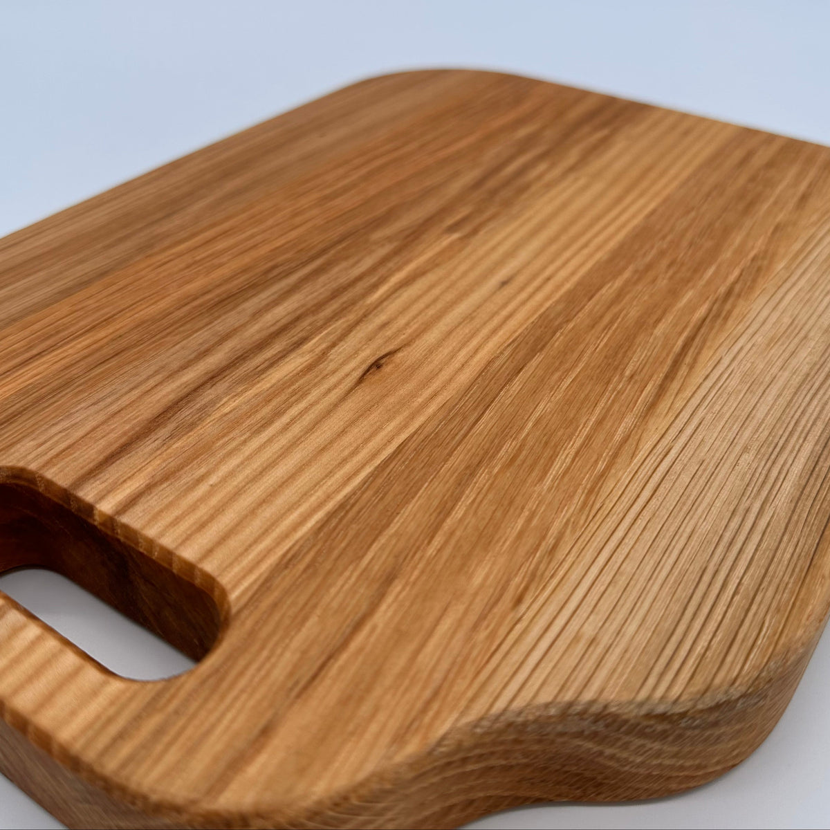 Wooden cutting board with a handle on a white background