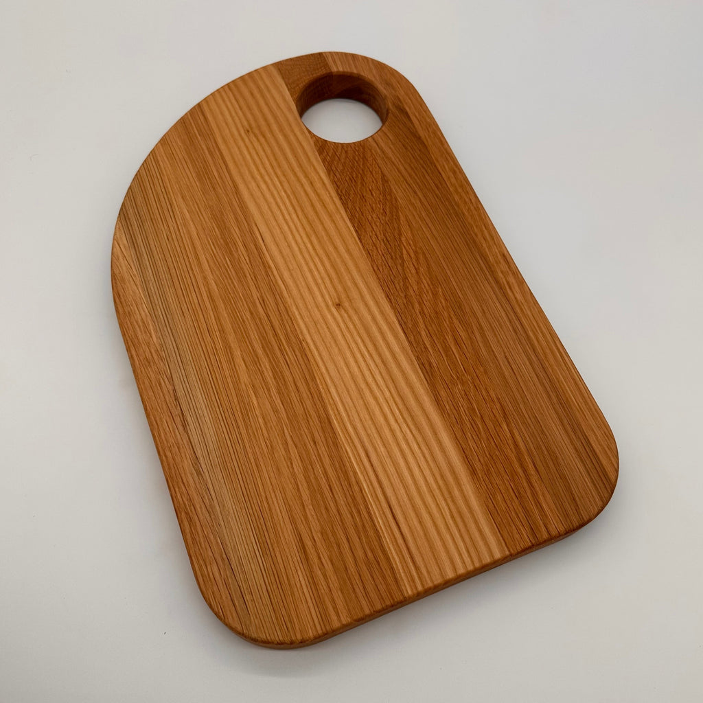 Wooden cutting board with a handle on a light gray background
