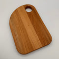 Wooden cutting board with a handle on a light gray background