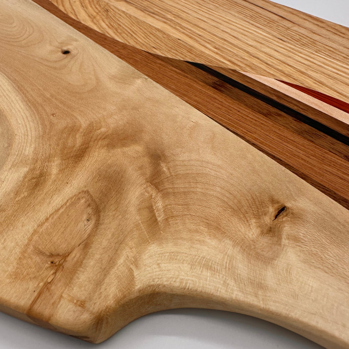 Close-up of a wooden cutting board with a natural grain pattern on a white background