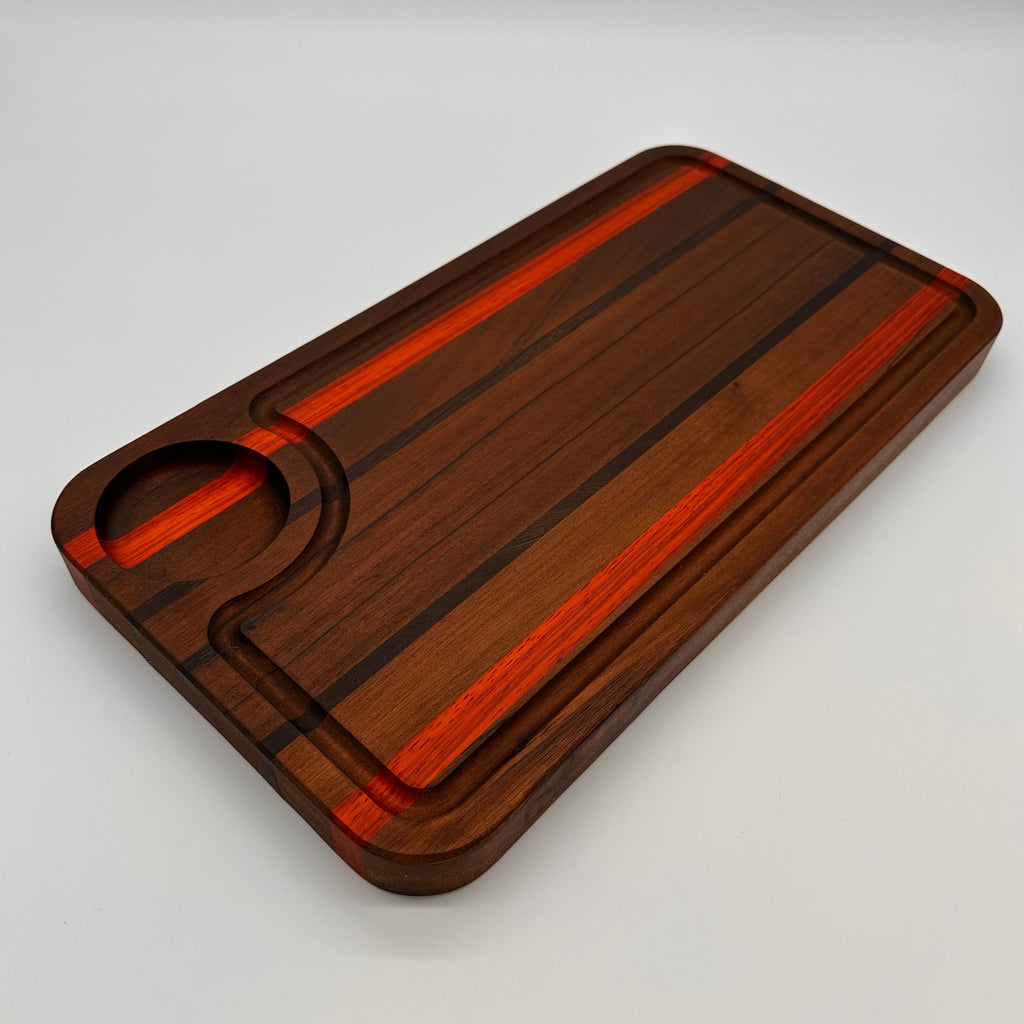 Wooden cutting board with a red stripe on a gray background