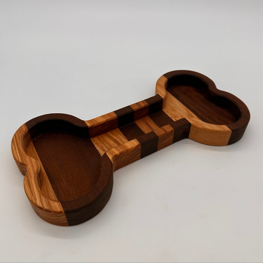 Wooden dog bone-shaped toy on a light gray background