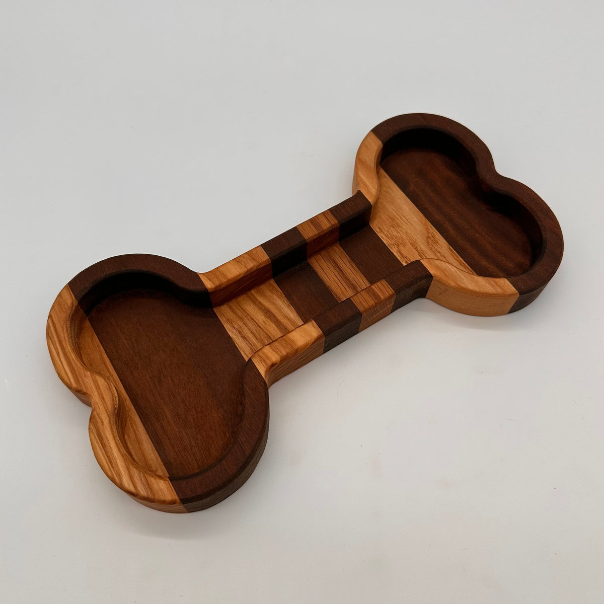 Wooden dumbbell-shaped object on a light gray background