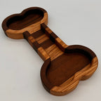 Wooden dog bone-shaped tray on a light gray background
