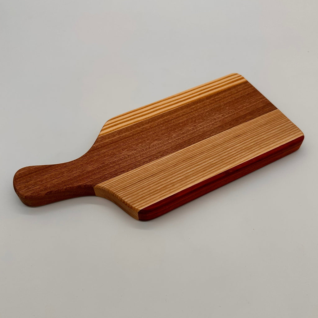 Wooden cutting board with a handle on a light gray background