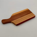 Wooden cutting board with a handle on a light gray background