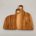 Two wooden cutting boards with handles on a light gray background